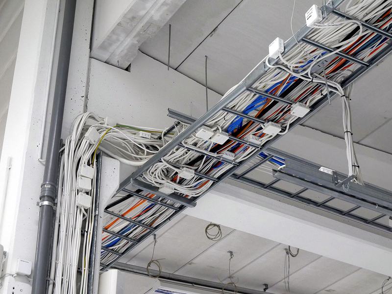 Een kabelgoot aan het plafond vol netjes gebundelde kabels