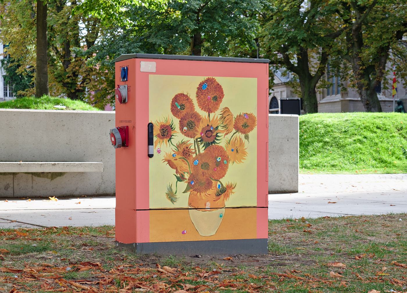 Een elektriciteitskast in een park in Mechelen, beschilderd met zonnebloemen